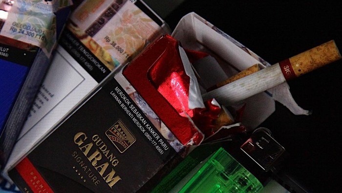Pedagang kaki lima (PKL) menunggu pembeli dan menunjukkan pita cukai yang menempel di bungkus rokok di Jakarta, Minggu (20/9/2025). Menteri Keuangan (Menkeu) Purbaya Yudhi Sadewa menyatakan kaget atas tarif cukai rokok yang sangat tinggi mencapai 57%.