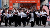 Dalam perlombaan legendaris ini, peserta ditantang untuk berlari sambil membawa nampan berisi secangkir kopi, croissant, dan segelas air tanpa menumpahkan isinya. REUTERS/Stephanie Lecocq