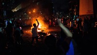 Suasana semakin panas ketika massa, banyak di antaranya berpakaian hitam dan mengenakan penutup wajah, melempari polisi dengan batu. REUTERS/Lisa Marie David