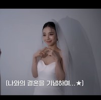 “Aku harus mengirimnya ke ibuku. Ibu aku menikah hari ini,” ujarnya sebelum meminta bantuan staff mengabadikan fotonya dalam balutan gaun pengantin. Foto: dok. SM Entertainment