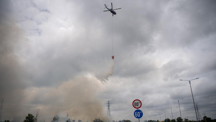 Water Bombing Dikerahkan, Api di Lahan Ogan Ilir Berhasil Dipadamkan Petugas dari Manggala Agni Daops Banyuasin berupaya melakukan pemadaman kebakaran lahan yang terjadi di sisi gerbang tol rambutan Jalan Tol Trans Sumatera (JTTS) ruas Palembang-Indralaya (Palindra) di Desa Rambutan, Ogan Ilir (OI), Sumatera Selatan, Minggu (21/9/2025). Kebakaran lahan yang terjadi sejak Sabtu (20/9) tersebut berhasil dipadamkan oleh petugas gabungan dari Manggala Agni Daops Banyuasin, Manggala Agni Daops Lahat, Manggala Agni Daops OKI, BPBD Kab Ogan Ilir (OI) dan dibantu dua helikopter water boombing milik BNPB. ANTARA FOTO/Nova Wahyudi