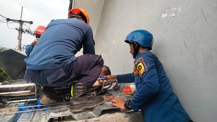 Damkar Kabupaten Bogor evakuasi kuli bangunan yang tersengat listrik.