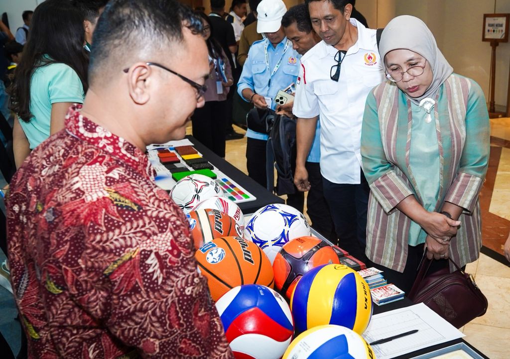 Direktur Jenderal Industri Kecil, Menengah, dan Aneka (IKMA) Reni Yanita mengamati berbagai produk bola yang diproduksi oleh pelaku IKM dalam negeri. (Dok. Kemenperin)