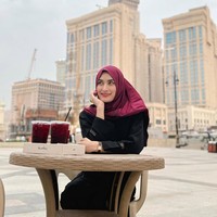 Wanita kelahiran 27 Agustus 1997 itu tampil berbeda dengan hijab merah marun saat bersantai di kafe dekat Menara Abraj Al-Bait, Mekkah. Foto: Dok. Instagram/@angbeenrishi.