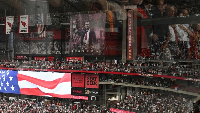 People stand up for the U.S. national anthem while attending a memorial service for slain conservative commentator Charlie Kirk at State Farm Stadium, in Glendale, Arizona, U.S., September 21, 2025. REUTERS/Callaghan O'Hare