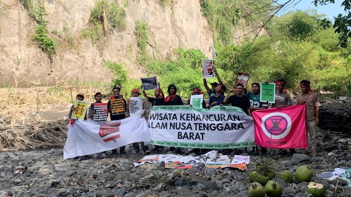 Mahasiswa dan pemuda dari Koalisi Extinction Rebellion (XR) Lombok membentangkan spanduk dan poster di lokasi galian C Desa Korleko, Kecamatan Labuhan Haji, Lombok Timur, NTB, Senin (22/9/2025). (Sanusi Ardi W/detikBali)