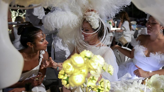 People attend Diner en Blanc, the French-inspired secret pop-up dinner, in Robert F. Wagner Jr. Park, in New York, U.S., September 19, 2025. REUTERS/Jeenah Moon