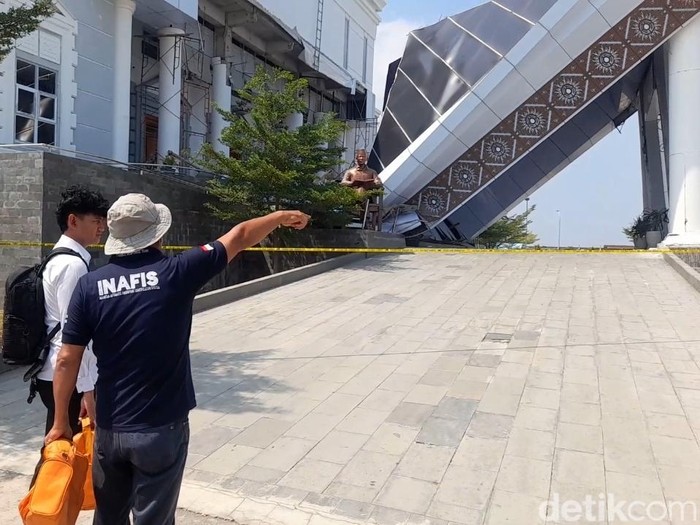 Petugas Inafis Polres Brebes melakukan pemeriksaan di lokasi ambruknya atap teras gedung KPT Brebes, Senin (22/9/2025).