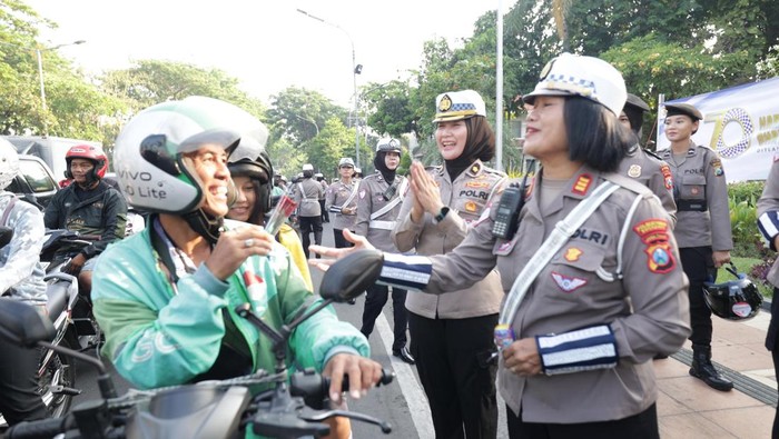 Puluhan polwan di Kota Surabaya membagikan helm, bunga higga cokelat ke pengendara