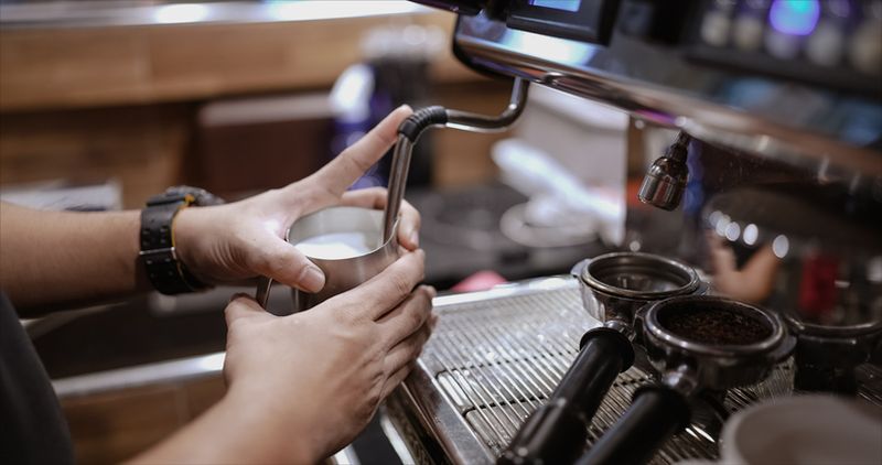 Posisikan milk jug dengan steam wand dengan benar.