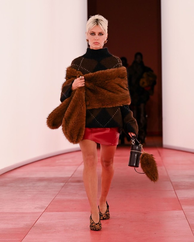 Iris Law, putri dari aktor Jude Law dan aktris Sadie Frost, tampil dengan sweater hitam yang dipadu rok mini merah. Wanita 24 tahun ini memang telah lama mengincar profesi modeling dan telah berjalan di catwalk sejumlah brand ternama, termasuk Versace. Foto: Instagram/@hm