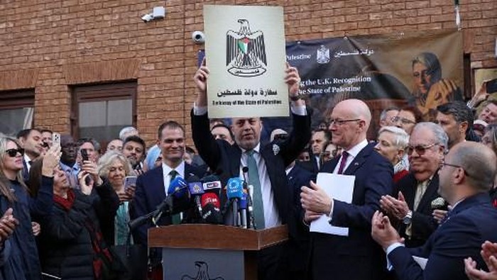 Head of the Palestine Mission to the UK, Husam Zomlot reacts as he holds a plaque with the words Embassy of the State of Palestine, during a flag-raising ceremony outside their Mission in west London on September 22, 2025. UK Prime Minister Keir Starmer on Sunday said Britain was formally recognising a State of Palestine, in a historic shift in decades of British foreign policy. (Photo by Adrian DENNIS / AFP)