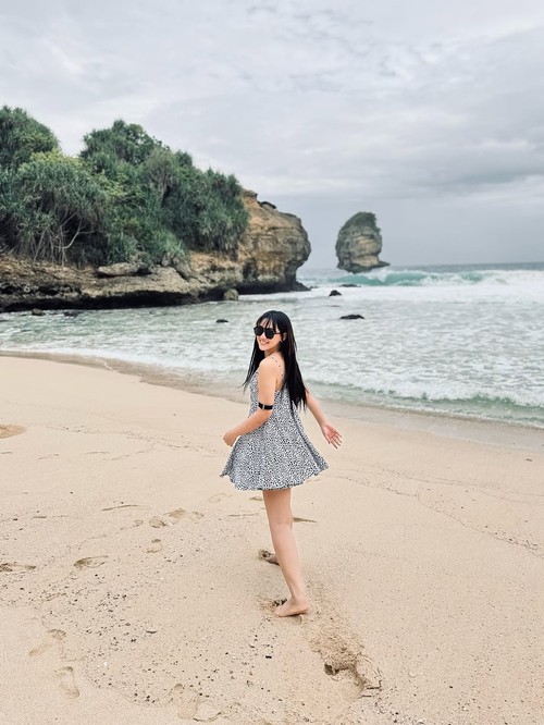 Happy Asmara main di pantai.
