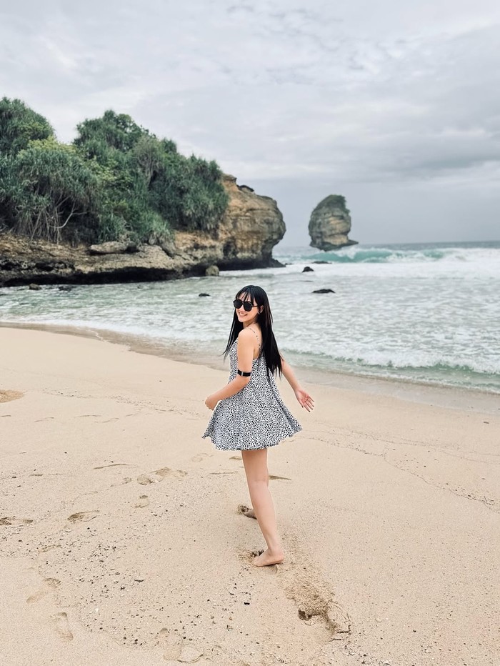 Happy Asmara main di pantai.