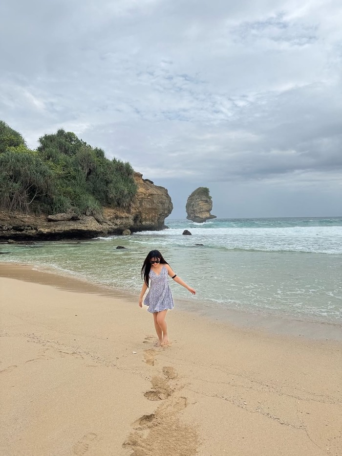 Happy Asmara main di pantai.