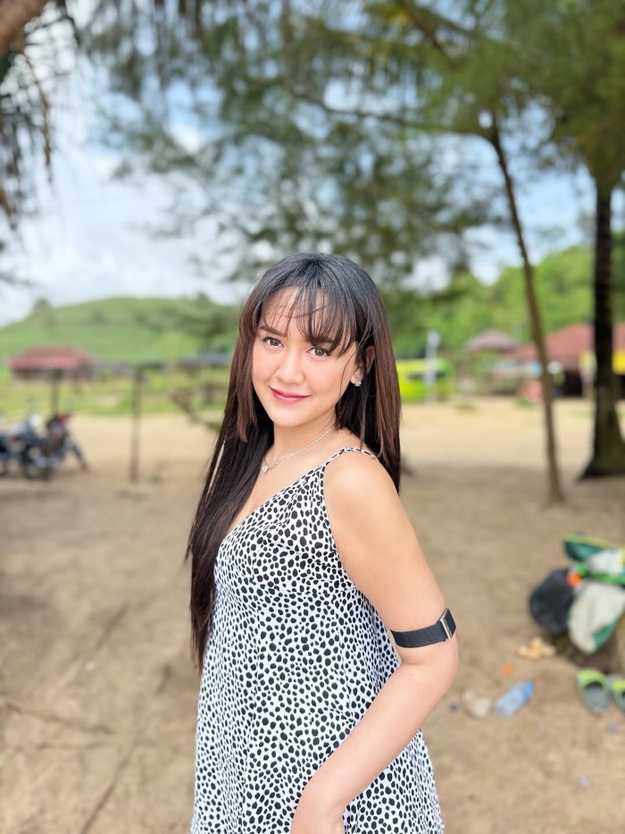 Happy Asmara main di pantai.