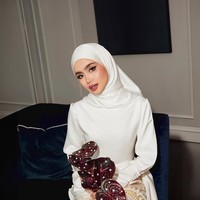 Hijab putih satin polos dipadukan Sashfir dengan gaya clean tucked, tanpa lipatan berlebihan. Kesan anggun semakin kuat karena kain hijab tampak berkilau di bawah cahaya. Foto: Dok. Instagram @sashfir.