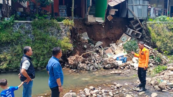 Turap sungai Ciomas, Kecamatan Ciomas, Kabupaten Bogor mengalami longsor usai hujan deras. Longsor mengakibatkan dua rumah di atas tebing mengalami kerusakan. (dok BPBD Kab Bogor)