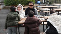 Harus menunggu waktu masuk ke penginapan yang lama, Zaskia dan Hanung memilih taman umum untuk bersantai dan makan. Ia bahkan memastikan anak-anaknya makan dengan benar sambil menyuapinya. Foto: Instagram/zaskiaadyamecca