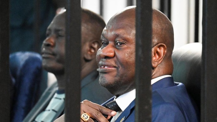 Suasana tegang menyelimuti Freedom Hall, Juba, pada Selasa (24/9/2025), ketika Wakil Presiden Pertama Sudan Selatan yang diskors, Riek Machar, duduk di balik jeruji baja ruang persidangan. Machar bersama Jenderal Gabriel Duop Lam dan terdakwa lainnya menghadapi dakwaan berat: pengkhianatan dan kejahatan terhadap kemanusiaan. REUTERS/Jok Solomun