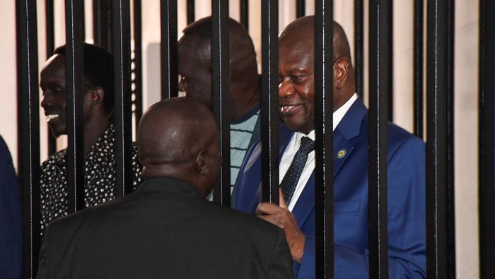 Di Balik Jeruji Baja, Riek Machar Jalani Sidang Pengkhianatan di Juba Suasana tegang menyelimuti Freedom Hall, Juba, pada Selasa (24/9/2025), ketika Wakil Presiden Pertama Sudan Selatan yang diskors, Riek Machar, duduk di balik jeruji baja ruang persidangan. Machar bersama Jenderal Gabriel Duop Lam dan terdakwa lainnya menghadapi dakwaan berat: pengkhianatan dan kejahatan terhadap kemanusiaan. REUTERS/Jok Solomun