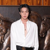 Jin BTS juga mendobrak batasan berpakaian pria dengan menjinjing koleksi leather hand bag hitam Gucci. Foto: Getty Images