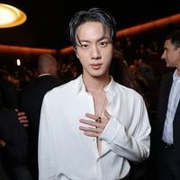 Pelantun ‘Butter’ itu mengenakan kemeja satin putih dengan kancing yang dibiarkan terbuka hingga mengekspos dadanya. Penampilannya dipadukan dengan celana panjang longgar berdana hitam dan belt beraksen logo Gucci. Foto: Getty Images