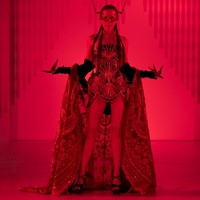 Perempuan 38 tahun itu tampil mengenakan bustier artistik dengan detail sulaman rumit bernuansa keemasan, dipadukan dengan jubah berpayet yang menjuntai megah. Aksesori berupa topeng ornamentik dan struktur kepala menyerupai antena menambah kesan teatrikal, membuat penampilannya bak karakter villain dalam film fantasi futuristik. (Foto: Dok. Senayan City)