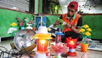 Salah satu hasilnya adalah lampu hias berwarna-warni yang indah. Botol plastik bekas dirangkai menyerupai kelopak bunga lalu dipasang pada rangkaian lampu.