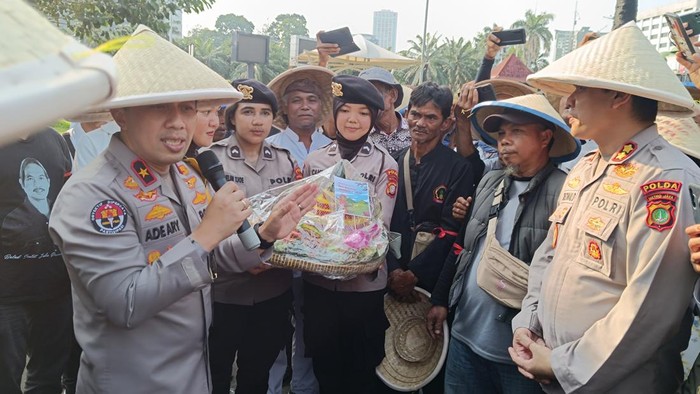 Polisi dan massa petani di DPR potong tumpeng peringati Hari Tani Nasional, Rabu (24/9/2025).