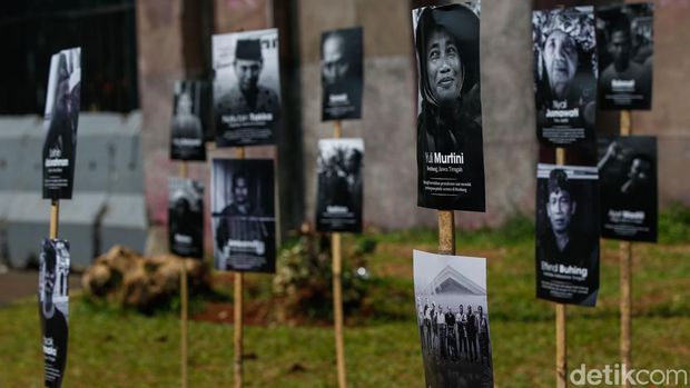 Seorang massa aksi melihat pameran foto wajah petani di depan DPR/MPR, Jakarta, Rabu (24/9/2025).