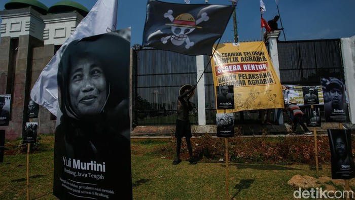 Potret Petani Korban Intimidasi Dipajang Saat Aksi di Depan DPR Seorang massa aksi melihat pameran foto wajah petani di depan DPR/MPR, Jakarta, Rabu (24/9/2025).