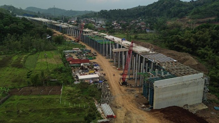 Foto udara kendaraan melintas di dekat pembangunan akses Jalan Tol Yogyakarta-Bawen Seksi 6, Bawen, Kabupaten Semarang, Jawa Tengah, Rabu (24/9/2025). Pembangunan Proyek Strategis Nasional (PSN) jalan tol akses Yogyakarta-Bawen Seksi 6 sepanjang 5,2 km di ruas Kabupaten Semarang dengan nilai investasi Rp1,67 triliun tersebut telah mencapai 75,7 persen dan ditargetkan rampung pada Desember 2025 guna mendukung konektivitas antar daerah serta pertumbuhan sektor pariwisata dan ekonomi lokal. ANTARA FOTO/Makna Zaezar