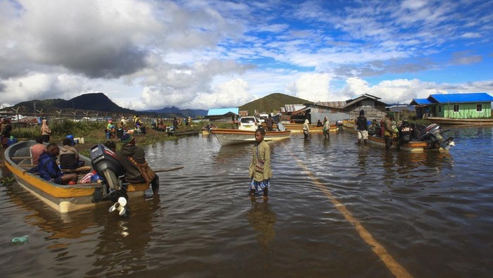 Seorang warga melintas di sekitar pinggiran Danau Paniai di Kampung Kogekotu, Kecamatan Paniai Timuri, Kabupaten Paniai, Provinsi Papua Tengah, Rabu (24/9/2025). Air Danau Paniai meluap menggenangi pinggiran danau setinggi 40- 60 cm akibat curah hujan yang cukup tinggi di wilayah itu. ANTARA FOTO/Gusti Tanati/nz