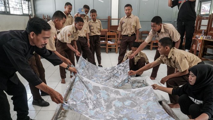 Mambuat seragam batik sekolah mandiri Guru dan siswa membuat kain motif marbling suminagashi atau teknik melukis kain di atas air untuk kain batik seragam sekolah di SMK Negeri I Plupuh, Sragen, Jawa Tengah, Kamis (25/9/2025). Sekolah setempat membuat seragam batik mandiri dari hasil karya siswa untuk dikenakan setiap hari Kamis dengan tujuan mengasah kreativitas anak serta mengajak siswa menghargai hasil karya seni. ANTARA FOTO/Mohammad Ayudha/rwa.