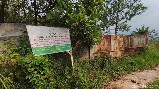 Pelang bertuliskan status tanah rampasan negara di Bogor