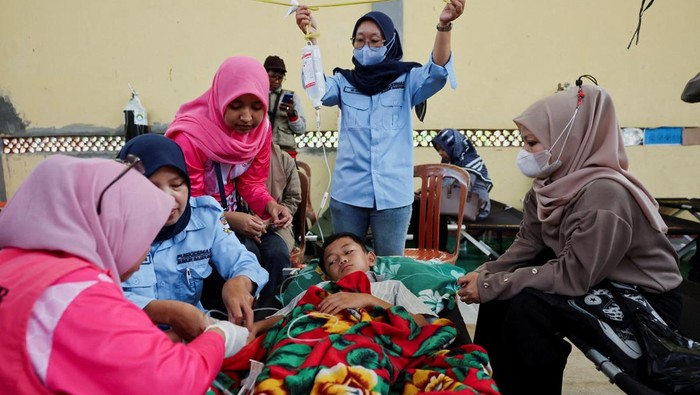 Naya Raisa Nuraini, 14, lies on a velbed while receiving treatments for food poisoning after eating government-sponsored free school meals, at a makeshift clinic inside a districts hall in Bandung, West Java province, Indonesia, September 25, 2025. REUTERS/Willy Kurniawan