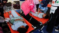 Sejumlah siswa menjalani perawatan akibat keracunan makanan di klinik darurat aula kecamatan Bandung, Jawa Barat, Kamis (25/9/2025). Kasus ini menambah deretan insiden serupa yang menimpa program andalan Presiden Prabowo Subianto tersebut. REUTERS/Willy Kurniawan  