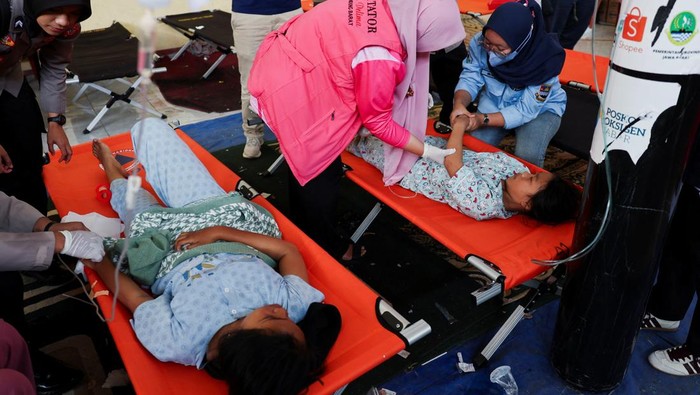 Naya Raisa Nuraini, 14, lies on a velbed while receiving treatments for food poisoning after eating government-sponsored free school meals, at a makeshift clinic inside a districts hall in Bandung, West Java province, Indonesia, September 25, 2025. REUTERS/Willy Kurniawan
