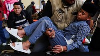 Seorang petugas menggendong Muhammad Nizam (13) yang sakit akibat keracunan makanan di Bandung, Jawa Barat, Kamis (25/9/2025). Di Kabupaten Bandung Barat, lebih dari 470 siswa sakit pada Senin, disusul tiga kejadian lain yang menimpa setidaknya 580 anak pada Rabu. REUTERS/Willy Kurniawan  