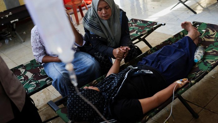 Naya Raisa Nuraini, 14, lies on a velbed while receiving treatments for food poisoning after eating government-sponsored free school meals, at a makeshift clinic inside a districts hall in Bandung, West Java province, Indonesia, September 25, 2025. REUTERS/Willy Kurniawan