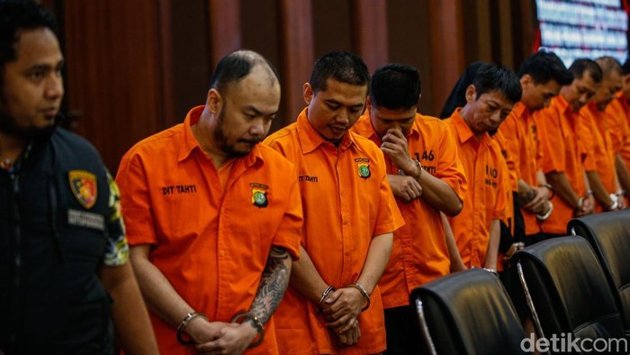 Pelaku memasuki ruangan saat konferensi pers di Mabes Polri, Jakarta, Kamis (25/9/2025). Bareskrim Polri membongkar sindikat pembobol rekening dormant pada bank BUMN di Jawa Barat dengan menangkap sembilan tersangka.
