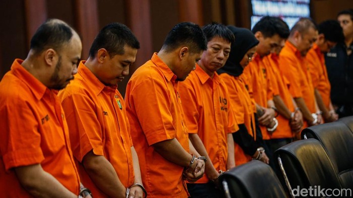 Pelaku memasuki ruangan saat konferensi pers di Mabes Polri, Jakarta, Kamis (25/9/2025). Bareskrim Polri membongkar sindikat pembobol rekening dormant pada bank BUMN di Jawa Barat dengan menangkap sembilan tersangka.
