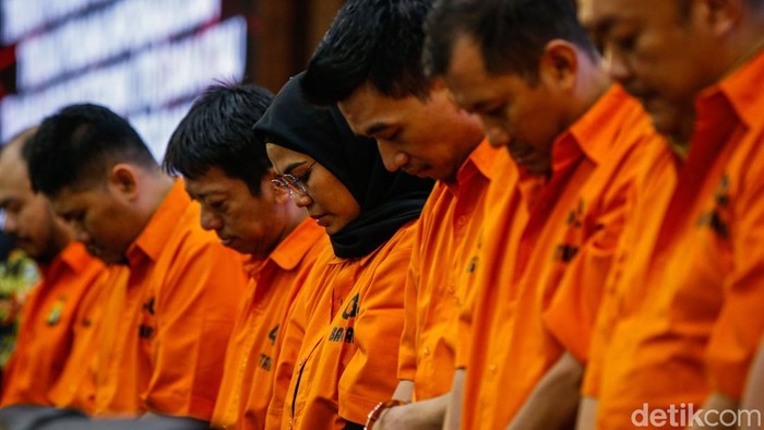 Pelaku memasuki ruangan saat konferensi pers di Mabes Polri, Jakarta, Kamis (25/9/2025). Bareskrim Polri membongkar sindikat pembobol rekening dormant pada bank BUMN di Jawa Barat dengan menangkap sembilan tersangka.