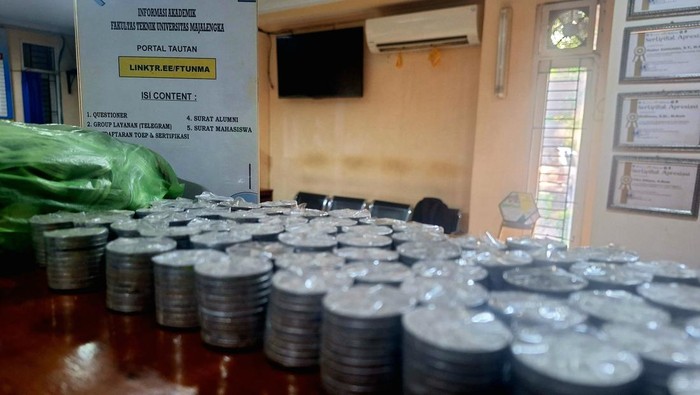 Uang receh celengan Dede Gunawan Sari untuk gelar sarjana.