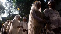 Sejumlah calon pengantin berjalan menuju lokasi akad nikah gratis di Bandung, Jumat (26/9/2025). Program ini diikuti 10 pasangan dengan fasilitas lengkap dari buku nikah hingga kartu keluarga. ANTARA FOTO/Novrian Arbi