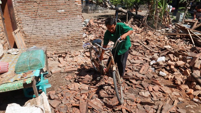 Dampak gempa di Banyuwangi Pemilik rumah memindahkan sepeda dari bangunan yang ambruk akibat gempa di Desa Bimorejo, Wongsorejo, Banyuwangi, Jawa Timur, Jumat (26/9/2025). Gempa 5,7 magnitudo yang terjadi di timur laut Banyuwangi pada Kamis (25/9) sore itu mengakibatkan tujuh bangunan di Banyuwangi rusak ringan hingga berat. ANTARA FOTO/Budi Candra Setya/bar