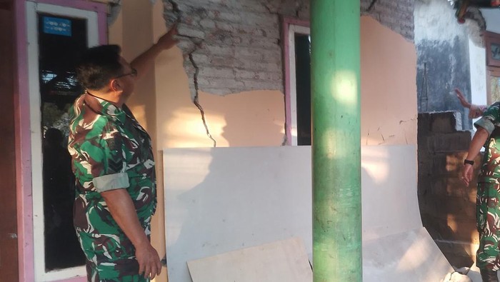 Anggota TNI menunjukkan tembok rumah warga yang retak akibat gempa di Desa Sumberwaru, Banyuputih, Situbondo, Jawa Timur, Kamis (25/9/2025). BPBD Kabupaten Situbondo Jawa Timur mencatat jumlah rumah rusak akibat gempa bumi dengan kekuatan magnitudo 5,7 sebanyak 50 rumah yang tersebar di empat desa. ANTARA FOTO/Sutikno/sgd/tom.