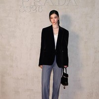 Visual grup KPop aespa, Karina tampil dengan gaya kasual memakai tanktop putih beremblem logo Prada di balik blazer berwarna hitam. Atasan tersebut dipadukan dengan denim jeans, serta high heels dan hand bag senada. Foto: Getty Images