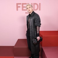 Leader grup KPop Stray Kids, Bang Chan tampil berani dalam balutan kemeja renda hitam semi transparan, yang mengekspos ototnya. Gayanya dilengkapi dengan jaket kulit Fendi. Foto: Getty Images